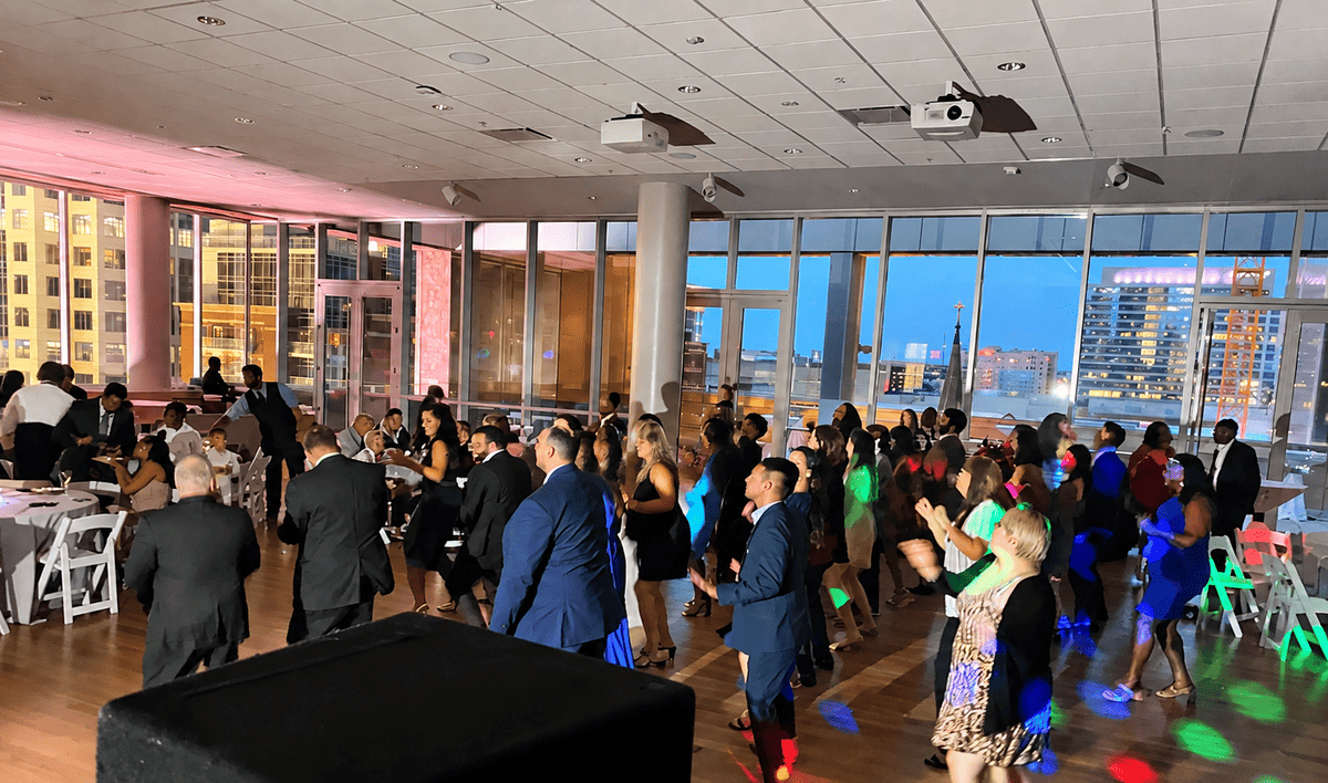 Wedding guests dancing at a Charlotte reception with warm uplighting